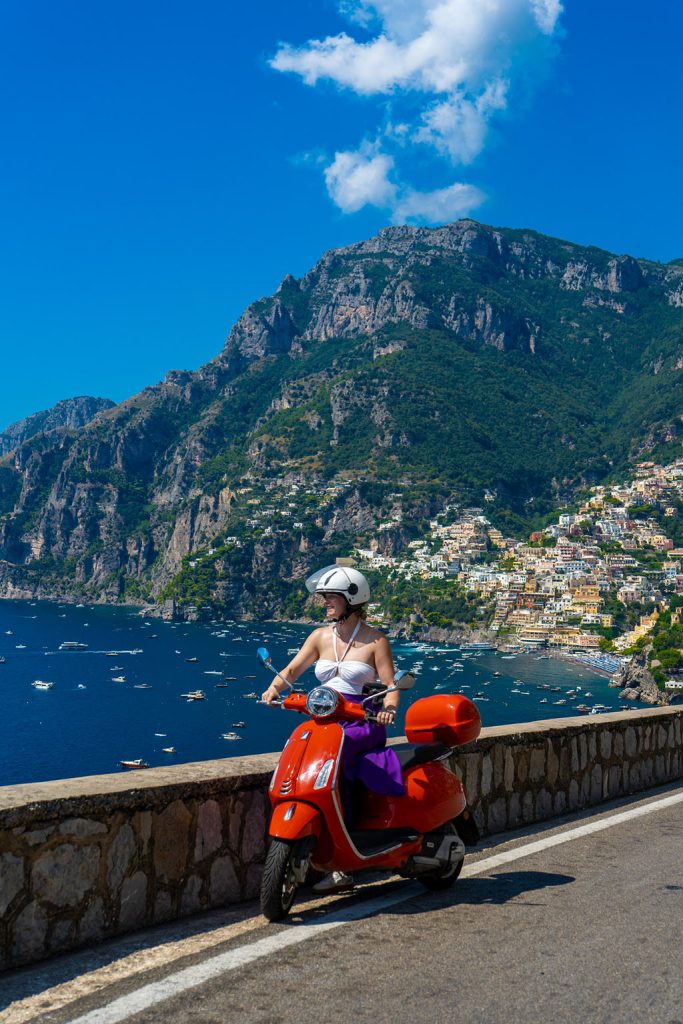 On a red Vespa along the village of Positano on the Amalfi Coast in Italy